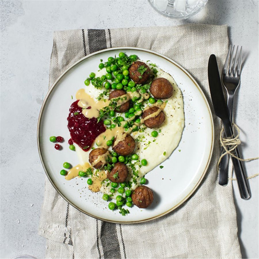 Meatballs with mashed potatoes, green peas, cream sauce and lingonberry jam
