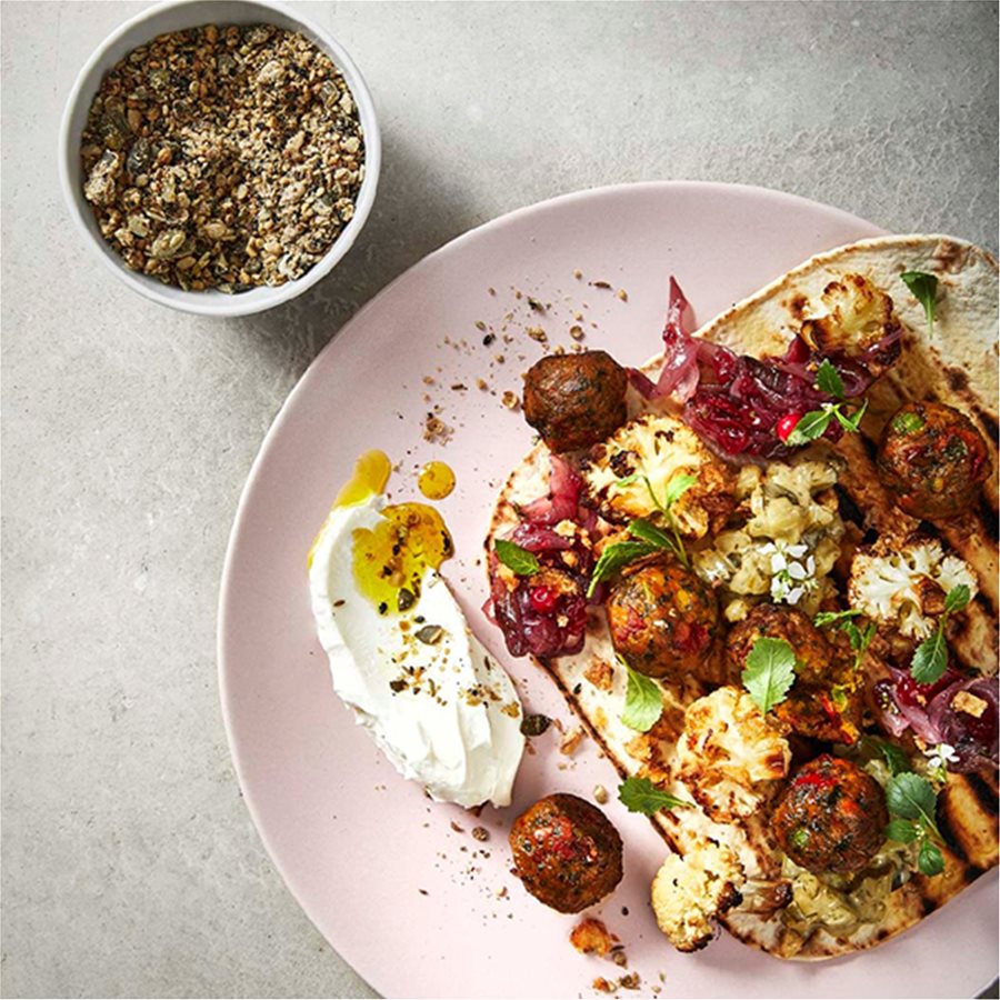 Veggie balls with roasted cauliflower on grilled flat bread served with yoghurt and dukkah